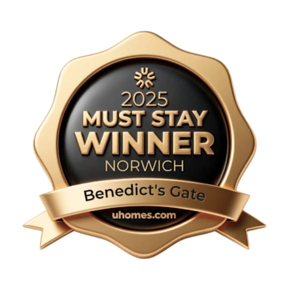 A gold badge with a black background that says "2025 MUST STAY WINNER NORWICH Benedict's Gate uhomes.com".
