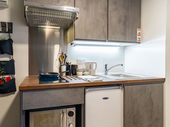Floor Plan  a small kitchen with stainless steel appliances and a wooden counter top