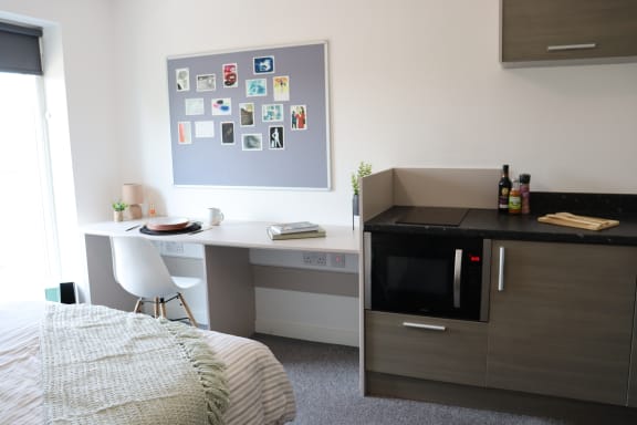 Floor Plan  a bedroom with a desk and in a room with a bed