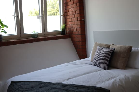 Floor Plan  a bedroom with a bed with pillows and a window