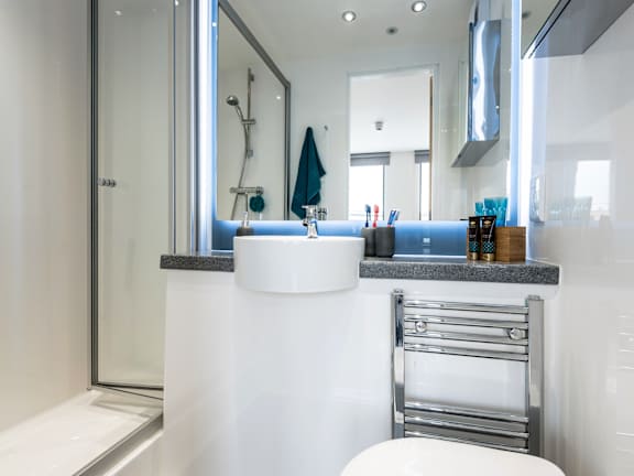 Floor Plan  A modern bathroom with a white sink and a glass shower door.