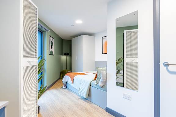 Floor Plan  A bedroom with a bed and a window with blinds.