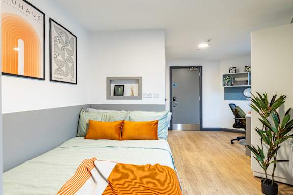 Floor Plan  A bedroom with a bed, a chair, and a plant.
