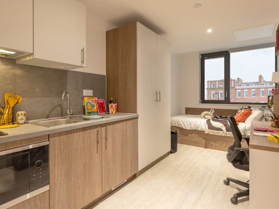 Floor Plan  a kitchen with a sink and a desk in a room with a bed