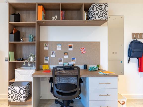 Floor Plan  A home office with a desk, chair, and shelves with various items.