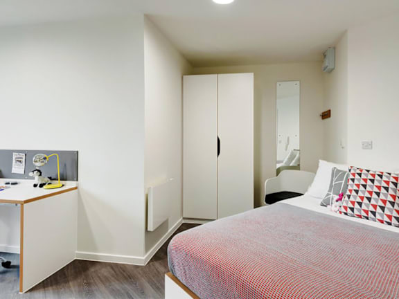 Floor Plan  A bedroom with a bed, desk, and wardrobe.