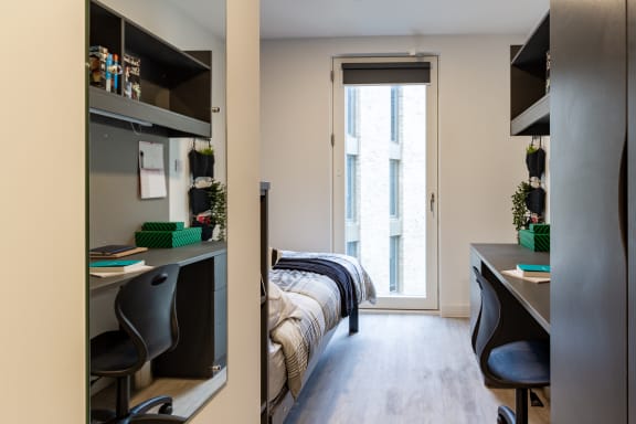Floor Plan  a bedroom with a bed and desk in a 555 waverly unit