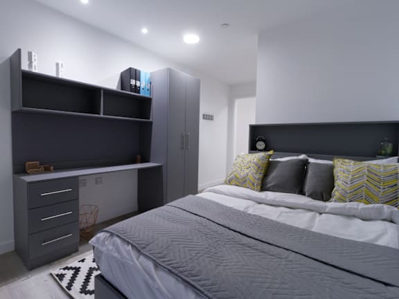 Floor Plan  A bedroom with a bed, desk, and drawers.