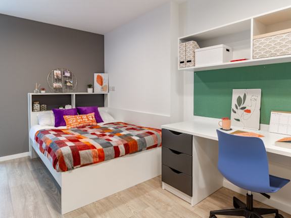 Floor Plan  A bedroom with a bed, desk, and chair.