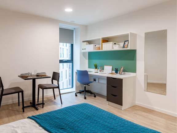 Floor Plan  A room with a desk, chairs, and a blue rug.