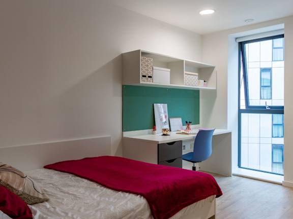 Floor Plan  A bedroom with a bed, desk, and chair.