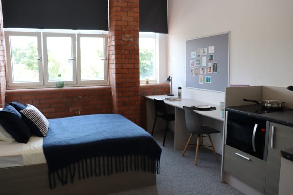 Floor Plan  a bedroom with a bed and a desk and a tv