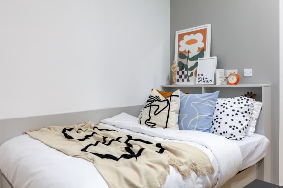 Floor Plan  a bedroom with a bed with black and white pillows and a blanket