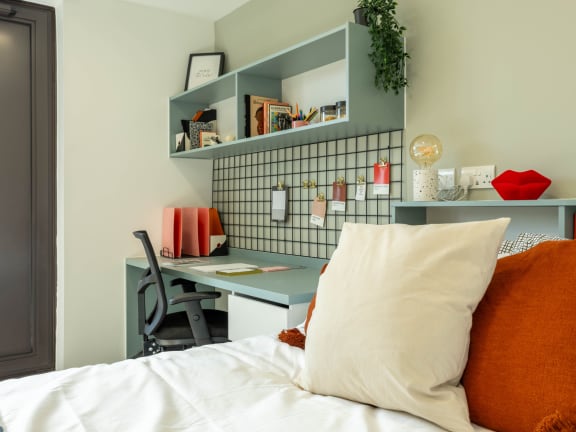 Floor Plan  a small bedroom with a bed and a desk with a chair