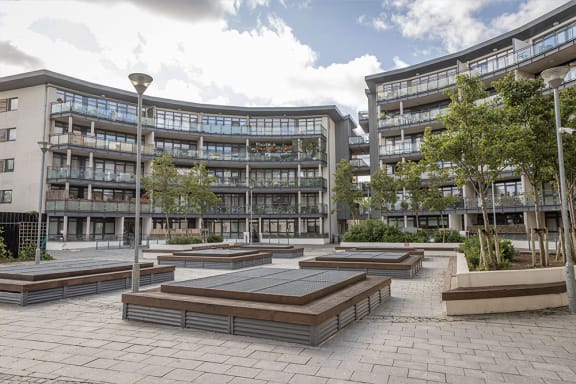 a view of a city courtyard with buildings and trees