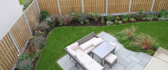 a garden with a seating area and a lawn