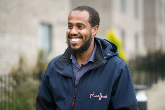 A man in a blue shirt is smiling at the camera.