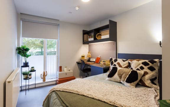 Floor Plan  a bedroom with a bed and a desk with a window
