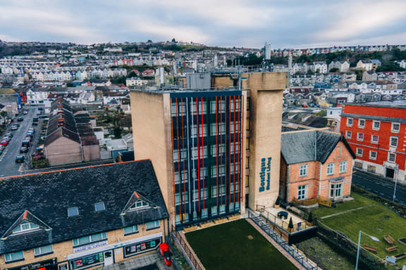 an aerial view of a building with a city in the background