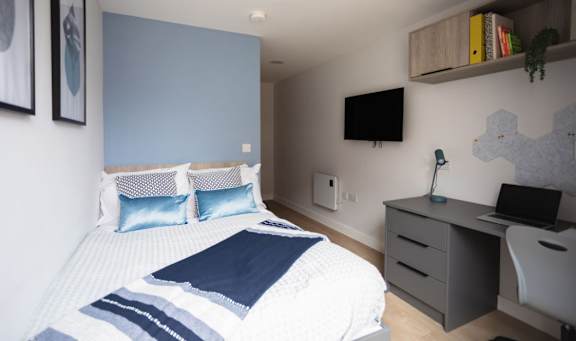 Floor Plan  a bedroom with a bed and a desk and a television