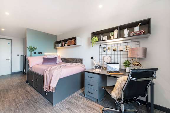 Floor Plan  a bedroom with a bed and a desk with a chair