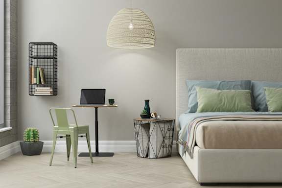 a bedroom with a bed and a desk with a laptop