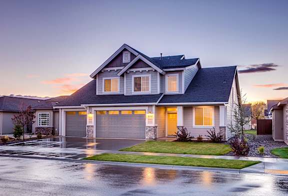 A house with a grey roof and a garage is shown.