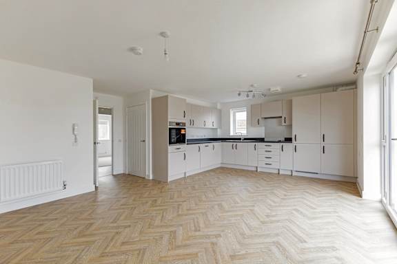 A spacious kitchen with a herringbone patterned floor.
