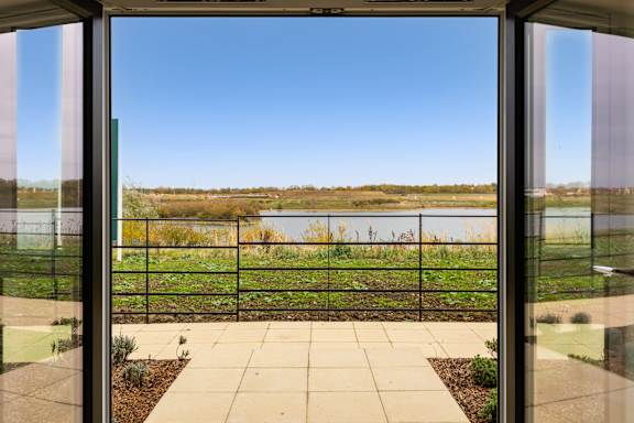 A glass door with a view of a field through it.
