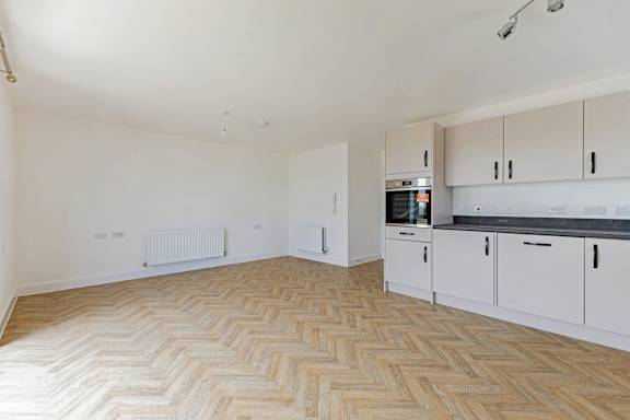 A room with a herringbone patterned floor and white walls.