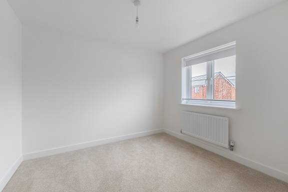 A room with a window and a radiator on the wall.