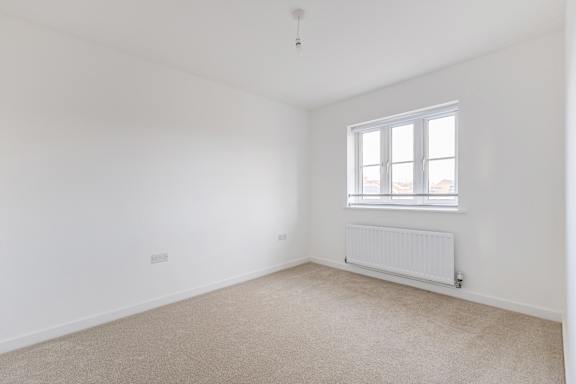 A room with a window and a radiator on the wall.