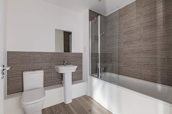 A white toilet sits next to a sink in a modern bathroom.