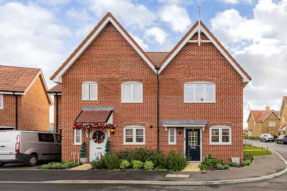 A red brick house with a white door and windows.