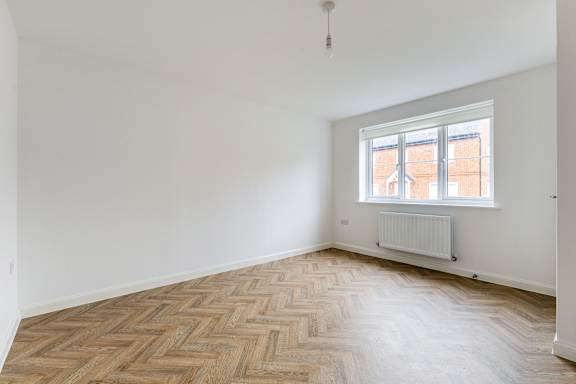 A room with a window and a radiator on the floor.