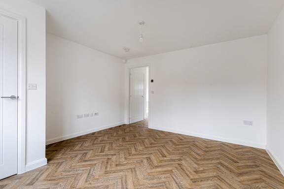 A room with a wooden floor and white walls.