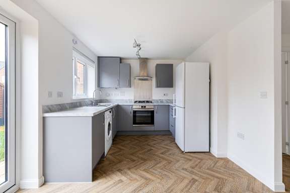 A kitchen with a white fridge and a white oven.