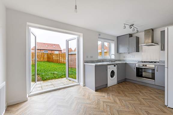 A kitchen with a washing machine and a refrigerator.