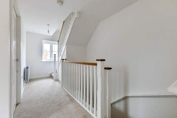 A white room with a staircase and a window.