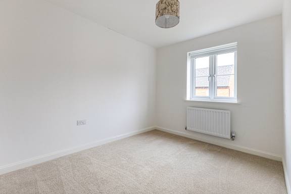 A room with a window and a radiator on the floor.