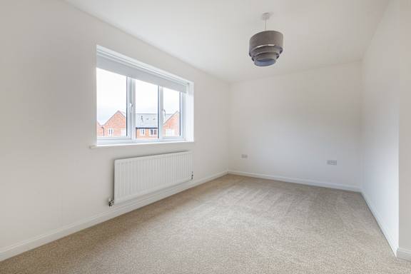 A room with a window and a radiator on the wall.