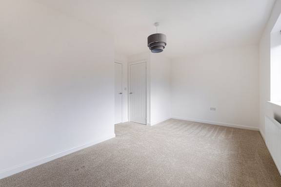 A room with a carpeted floor and a ceiling light.