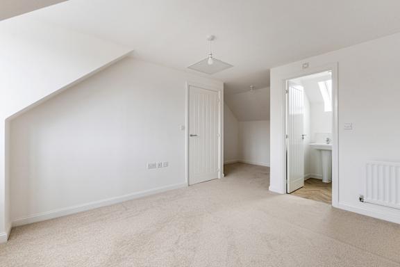 A white room with a carpeted floor and a white ceiling.