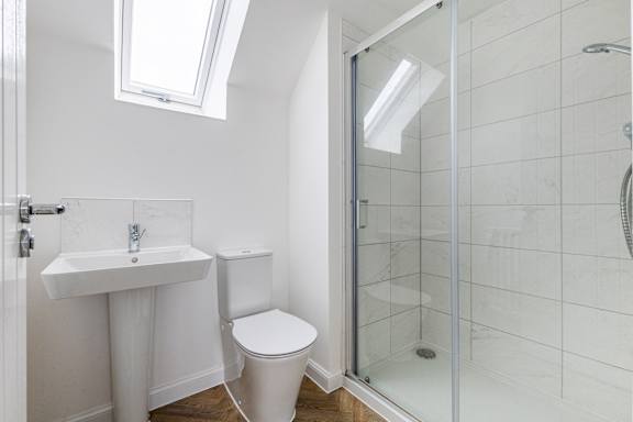 A white toilet sits next to a sink in a bathroom.