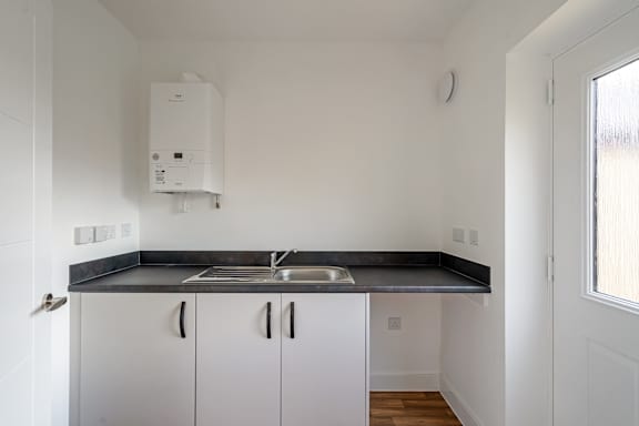 A kitchen with a sink and a wall-mounted water heater.
