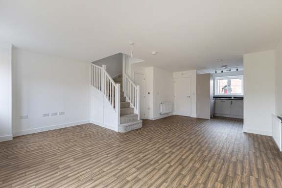 A room with wooden floors and a staircase.