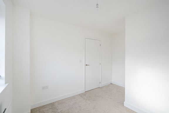 A white room with a door and a window.