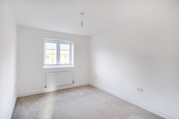 A room with a window and a radiator on the wall.