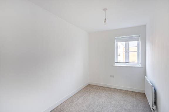 A room with a window and a radiator on the wall.