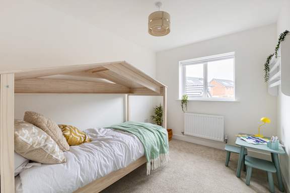 A bedroom with a canopy bed and a small table.